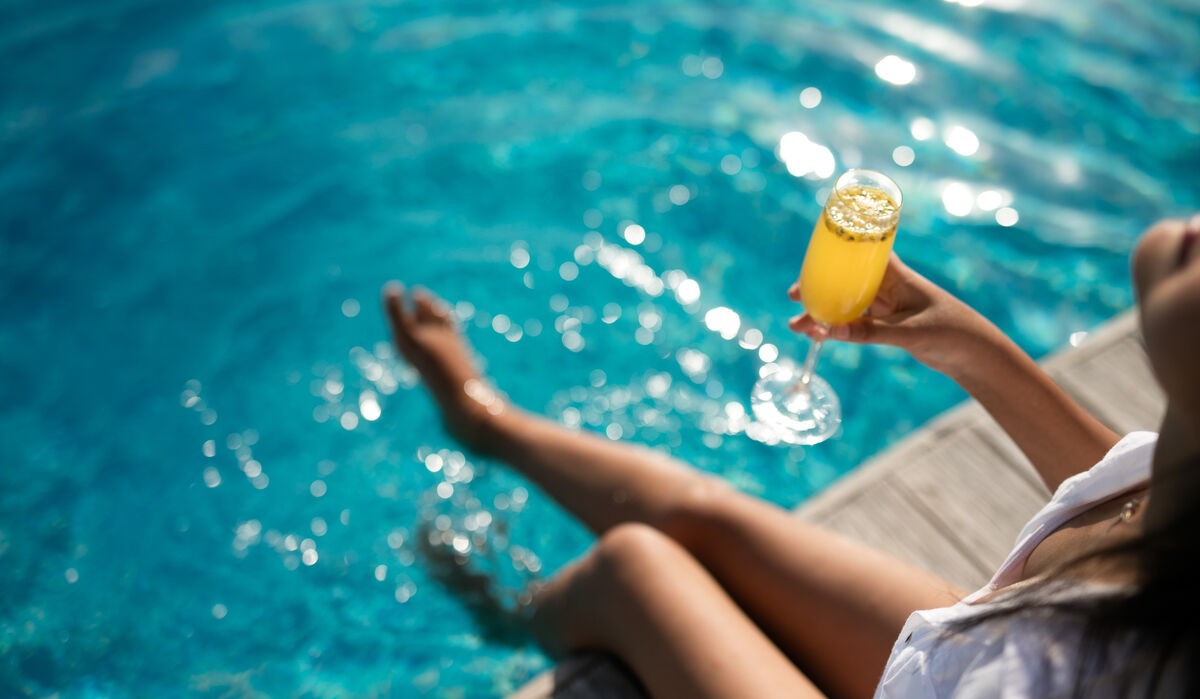 Woman enjoying a cocktail by the pool at Kandima Maldives