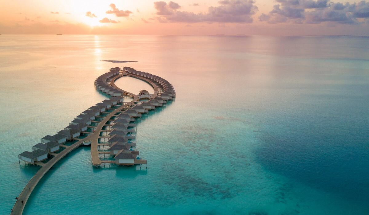 Sunset aerial of Kandima Maldives' water villas